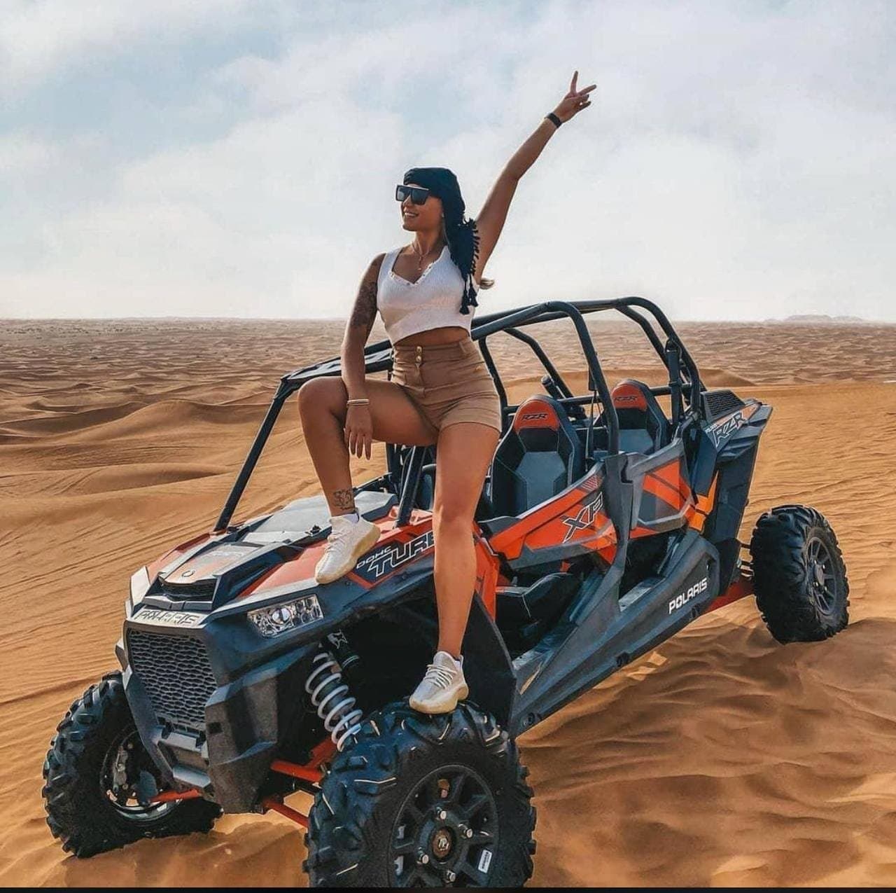 Guest standing on a 4-seater dune buggy on the red sand