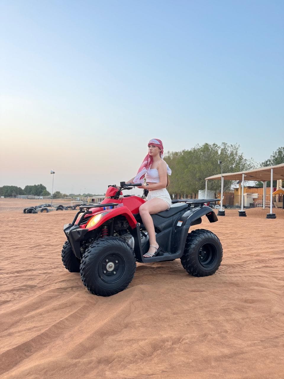 Guest on a red quad bike at sunset in the desert